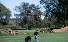 A golfer walks on the course in front of cut down trees at East Potomac Golf Links in Washington DC