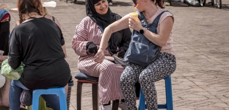 A henna tattoo artist draws on a tourist's arm in Jemaa el-Fnaa square in Marrakesh 