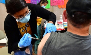 Registered Nurse Mariam Salaam administers the Pfizer booster shot at a Covid vaccination and testing site in Los Angeles on May 5, 2022