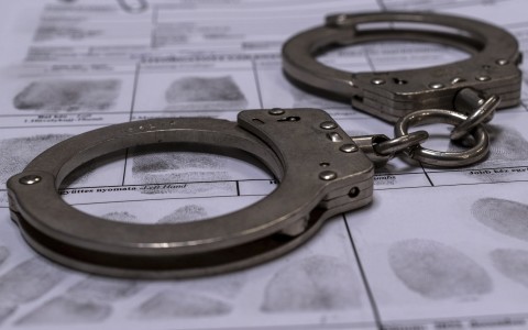 File: Handcuffs and a fingerprint card. GettyImages/Daniel Tamas Mehes
