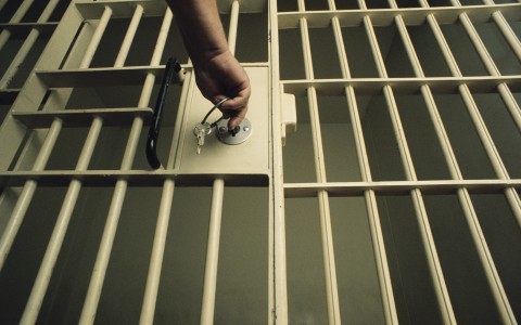 An officer locking a jail cell. GettyImages/Charles O'Rear