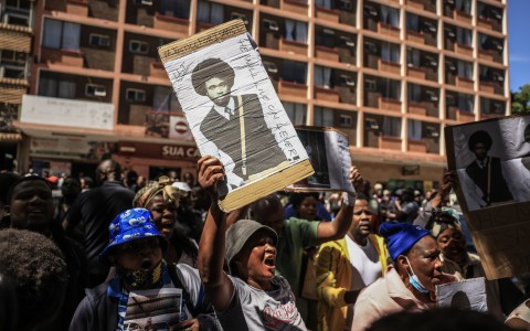A protester holds a placard with Isaac Satlat's picture. Gallo Images/Phill Magakoe