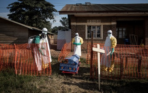 File: Medical workers disinfect the coffin of a deceased unconfirmed Ebola patient inside an Ebola Treatment Centre. AFP/John Wessels