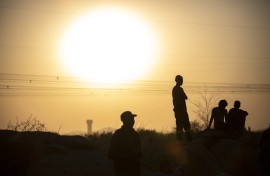 File: People are silhouetted as they gather at Wonderkop in Marikana, Rustenburg where striking miners were killed during the Marikana massacre. GULSHAN KHAN / AFP