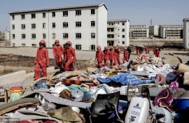 Members of the Red Ants stand next to personal belongings of people they removed from the apartments during a joint eviction operation between the Red Ants and the South African Police Service (SAPS) of people that illegally occupied apartment buildings in Roodepoort, near Johannesburg.