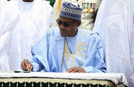 Nigerian President Muhammadu Buhari signs a register during a ceremony to mark the 59th anniversary of Nigeria's independence from England, on October 1, 2019 at the presidency in Abuja.