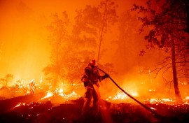 A firefighter douses flames as they push towards homes during the Creek fire in the Cascadel Woods area of unincorporated Madera County, California on September 7, 2020. 