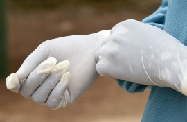 File: A health worker puts on medical gloves. PASCAL GUYOT / AFP