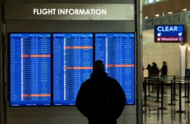 A traveler looks at a display listing cancelled and delayed flights at Ronald Reagan National Airport in Virginia on January 11, 2023