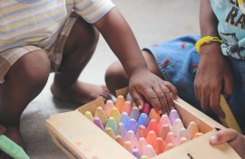 File: Children playing with chalk crayons.