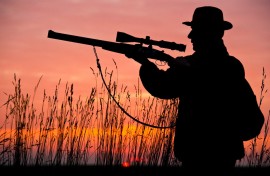 File: A hunter aims his rifle as the sun sets behind him. AFP/Patrick Pleul