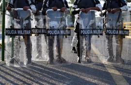 Mexican armed forces stand guard as Honduran migrants wait to cross from Guatemala to Mexico.
