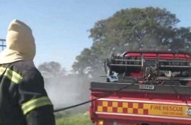 A firefighter next to a vehicle.