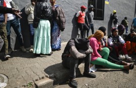 Residents, relatives of victims and members of the public gather at the site of a burned apartment block in Johannesburg. AFP/Luca Sola