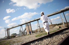 File: A mine worker walks to work. AFP/Paballo Thekiso