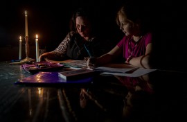 File: Marina Van Biljon (L) and her daughter, Nika, do homework during load-shedding in Frankfort. AFP/Shiraaz Mohamed