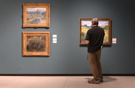 A visitor looks at a painting by Vincent van Gogh (R) next to paintings by Claude Monet and Camille Pissarro. AFP/Michal Cizek