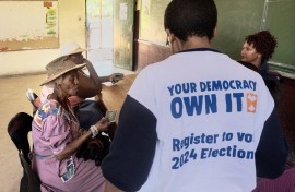 Two women give their identity documents to IEC officials to be registered as voters. AFP/Luca Sola
