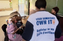 Two women give their identity documents to Electoral Commission of South Africa (IEC) officials to be registered as voters during the nationwide voter registration campaign ahead of the 2024 general elections at a voting station in Soweto on November 18, 2023.