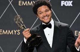 South African comedian Trevor Noah poses in the press room with the Outstanding Talk Series award for "The Daily Show With Trevor Noah". AFP/Robyn Beck