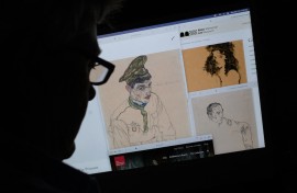 a person looking on a computer screen at artwork by Austrian Expressionist Egon Schiele entitled "Russian War Prisoner" (L), "Portrait of a Man" (R) and "Girl With Black Hair" (top), which were seized by investigators. AFP/Chris Delmas