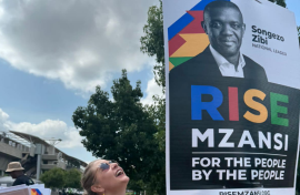 A RISE Mzansi member hanging a poster. Facebook/RISE Mzansi