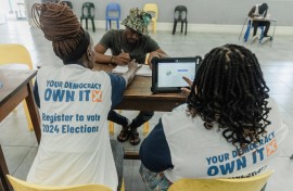 IEC officials assist a voter to be registered at a voting station. AFP/Rajesh Jantilal