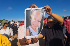Community members holding a photo of Joshlin Smith. eNCA/Nobesuthu Hejana