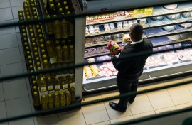 A customer takes a close look at prices while shopping in a grocery store. AFP/Jekesai Njikizana