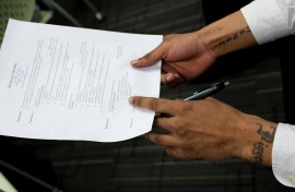 File: A job seeker holds his CV before and interview. Brooks Kraft LLC/Corbis via Getty Images