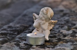 A cherub next to a candle. Pixabay/pasja1000