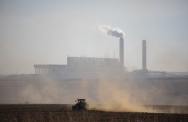 File: A farmer works with its tractor in front of the Kusile Power Station located in eMalahleni. AFP/Wikus de Wet