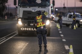 File: A South Africa Police Service's officer (SAPS) sets up a road block.