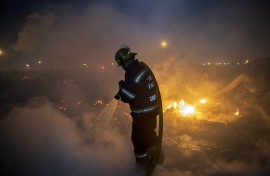 File: Members of the City of Cape Town Fire and Rescue Services extinguish a fire. AFP