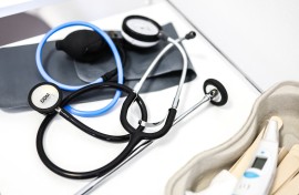 medical instruments including a stethoscope and thermometer as they lie on a table in a doctor's office. AFP/Charly Triballeau