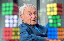 Hungarian inventor Erno Rubik sits next to several Rubik's Cubes. AFP/Attila Kisbenedek