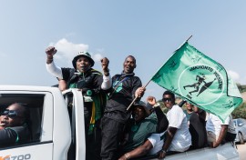 Supporters of the MK Party hold flags and chant slogans while celebrating. AFP/Rajesh Jantilal