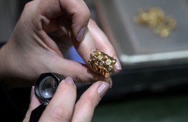 An appraiser examines a gold ring at a gold dealership in Buenos Aires. AFP/Juan Mabromata