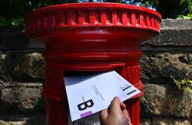 An envelope containing a Postal Vote for the upcoming UK General Election is posted in Birkenhead. AFP/Paul Ellis