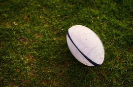 File: A rugby ball on an empty rugby field. GettyImages/PeopleImages