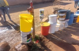 People queueing with buckets to get water. eNCA/Hloni Mtimkulu