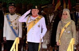 Malaysia's King Sultan Ibrahim Iskandar (C) saluting for the national anthem next to Queen Raja Zarith Sofiah. AFP/Malaysia's Department of Information