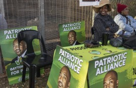 Patriotic Alliance (PA) supporters sit outside the Jan Hofmeyer Recreation Centre polling station in Brixton, Johannesburg on May 29, 2024, during South Africa’s general election.