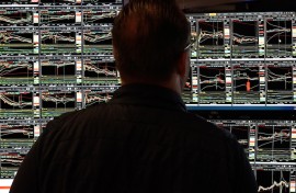 File: A trader looking at stock market graphs. AFP/Timothy A Clary