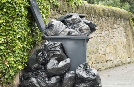 File: A full wheelie bin with rubbish bags overflowing. GettyImages/georgeclerk