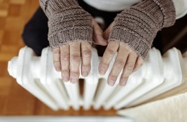 File: A man heats his hands over a heater. GettyImages/Jelena Stanojkovic