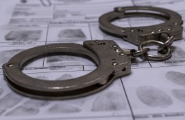 File: Handcuffs and a fingerprint card. GettyImages/Daniel Tamas Mehes