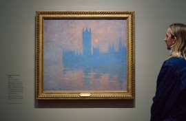 A gallery assistant studies a work by the french impressionist painter Claude Monet. AFP/Benjamin Cremel.jpg