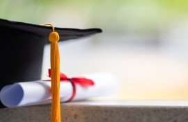 File: Close-up of a mortarboard and degree certificate. GettyImages/sengchoy