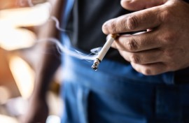 File: A man holding a smoking cigarette in his hand. GettyImages/SimpleImages